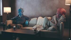 Two aliens sit on a couch in a parody commercial for the Humanzapro drug from High on Life 2
